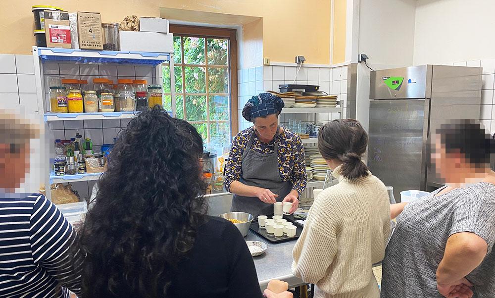 La cuisinière avec les participantes en train de préparer un gâteau