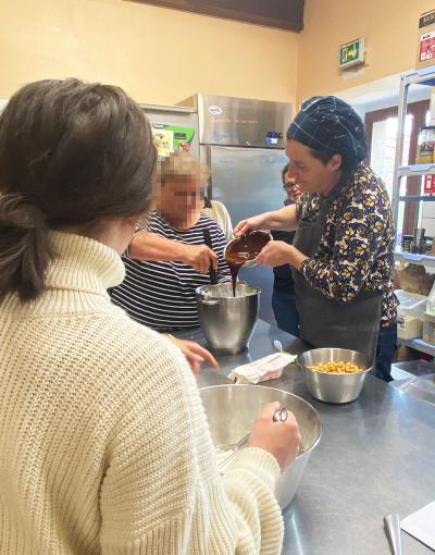 La cuisinière avec les participantes en train de préparer un gâteau